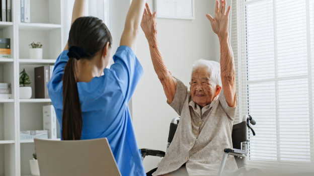 caregiver and resident working on a rehabilitative move together